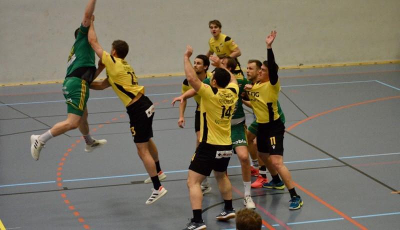 Handbollsspelare i gula och gröna spelskjortor mitt i en match
