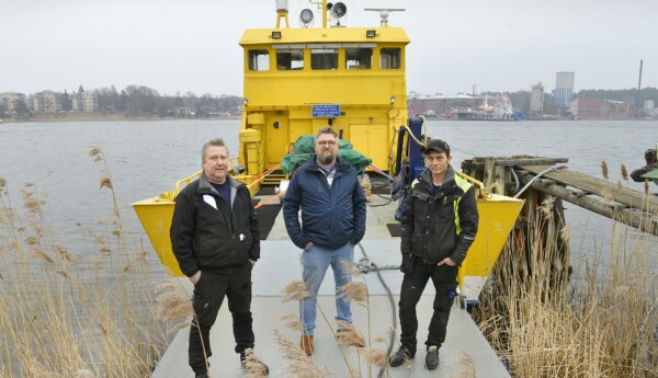 Tre män på rampen till en mindre färja