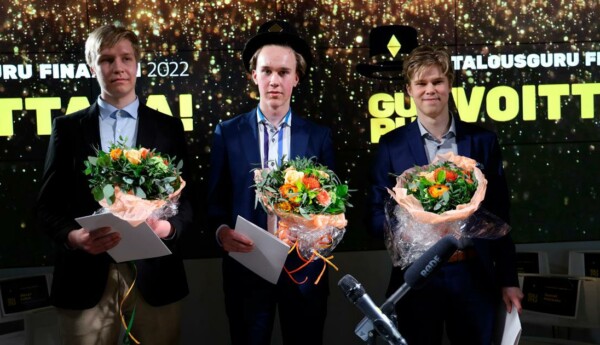 tre unga män står med blombuketter och diplom i händerna