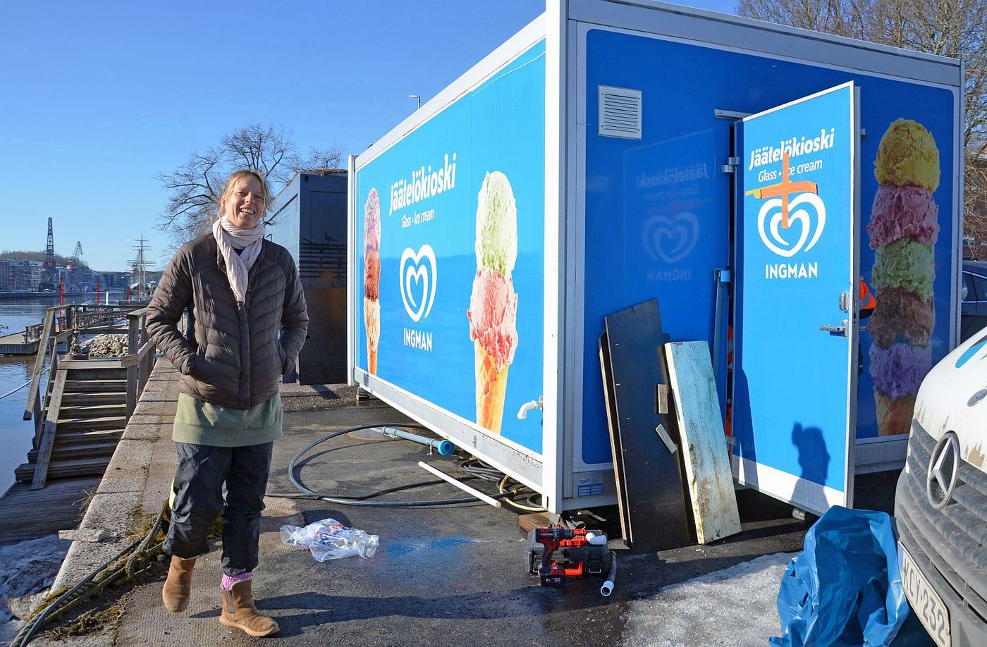 Glad kvinna vid åstrand och glasskiosk