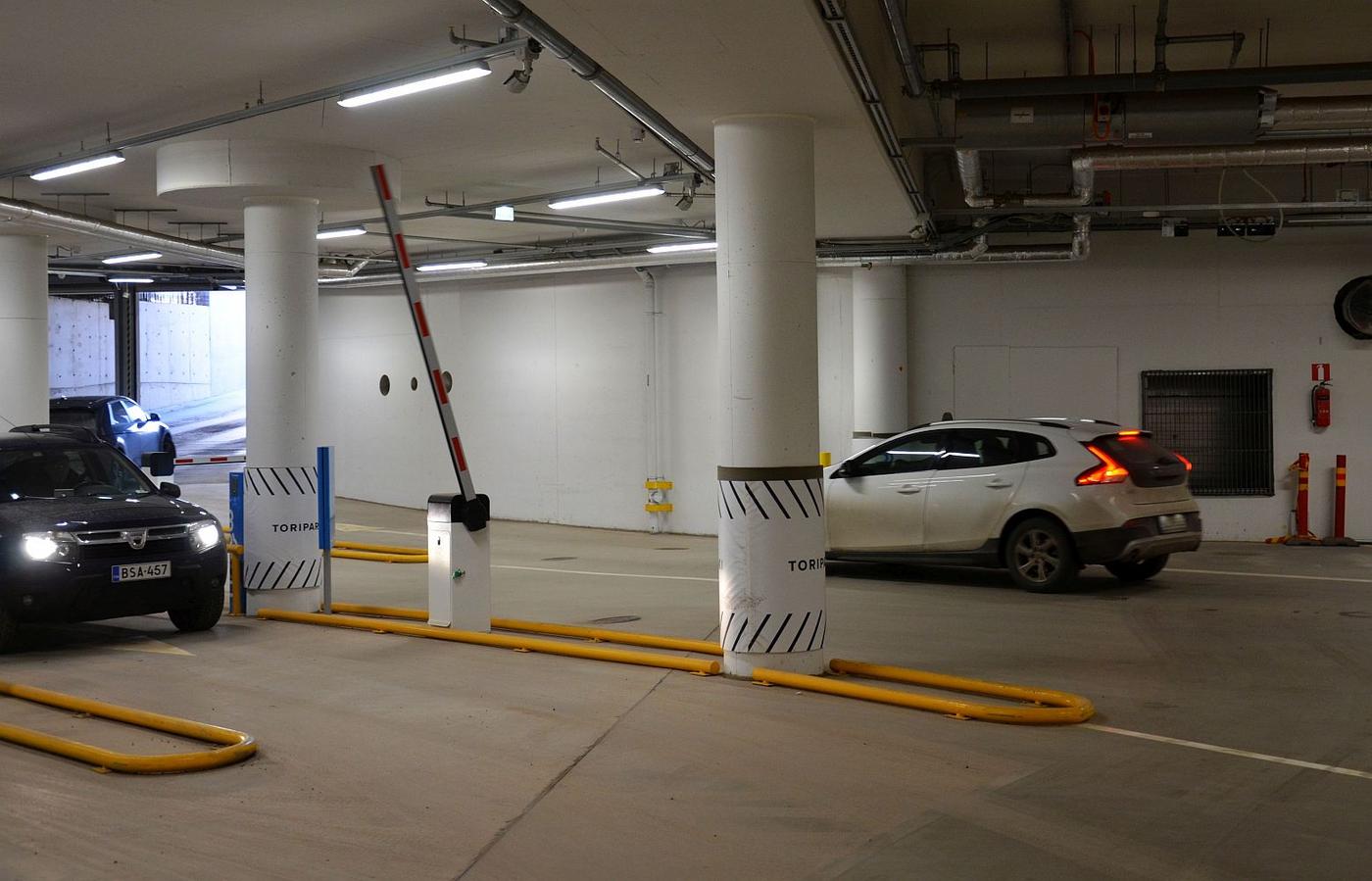 Bilar vid portar till underjordiskt parkeringsgarage
