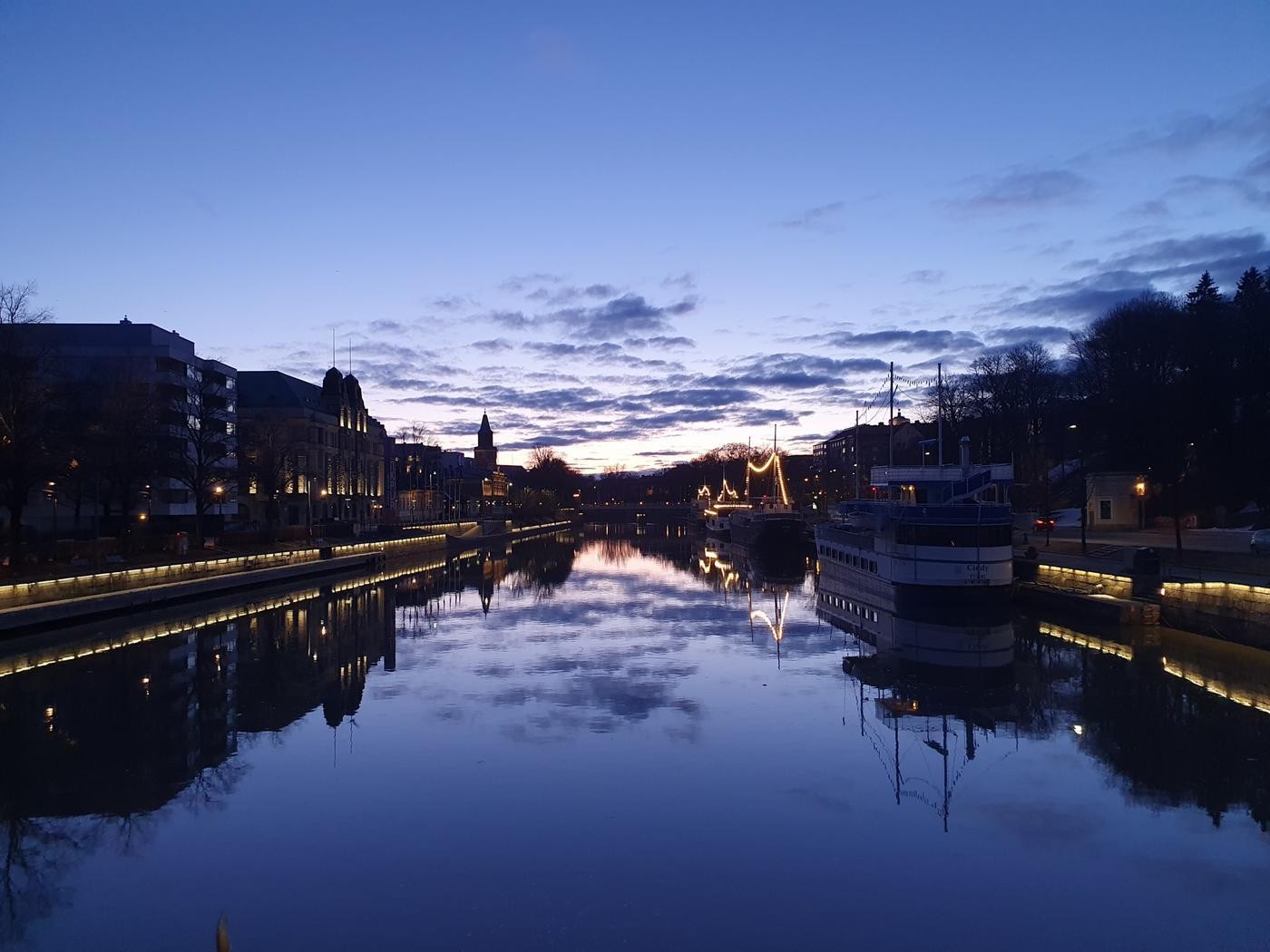 Aura å med sihuetten av Åbo domkyrka i bakgrunden.