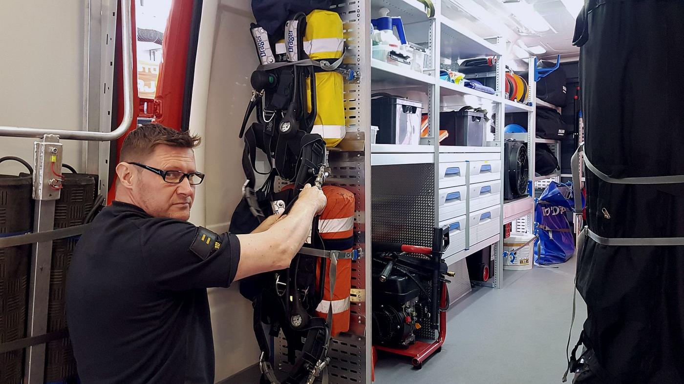Brandman inspekterar utryckningsbil