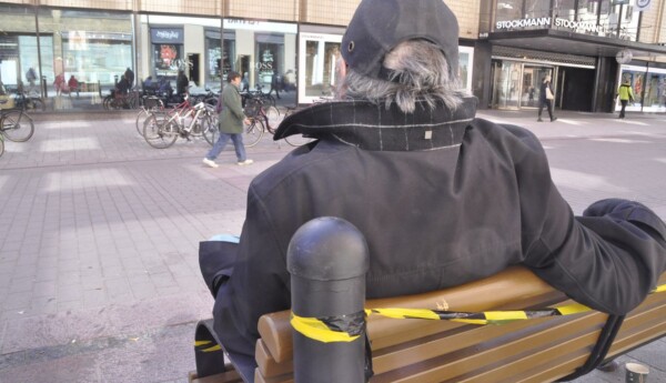 en man sitter på en bänk
