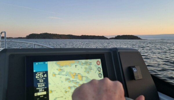 Solnedgång i skärgård, båt med plotter