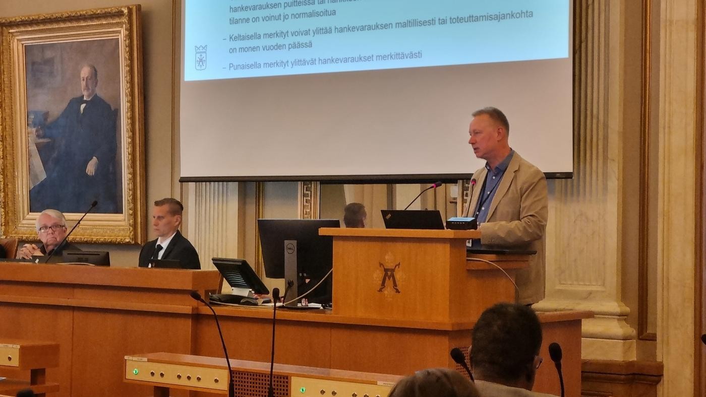 man i ljusbrun kavaj i talarstol