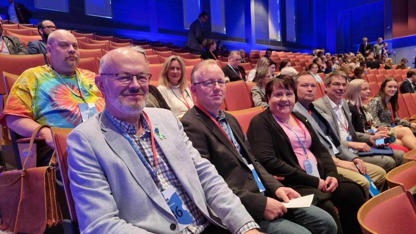 människor som sitter på rad i ett stort auditorium