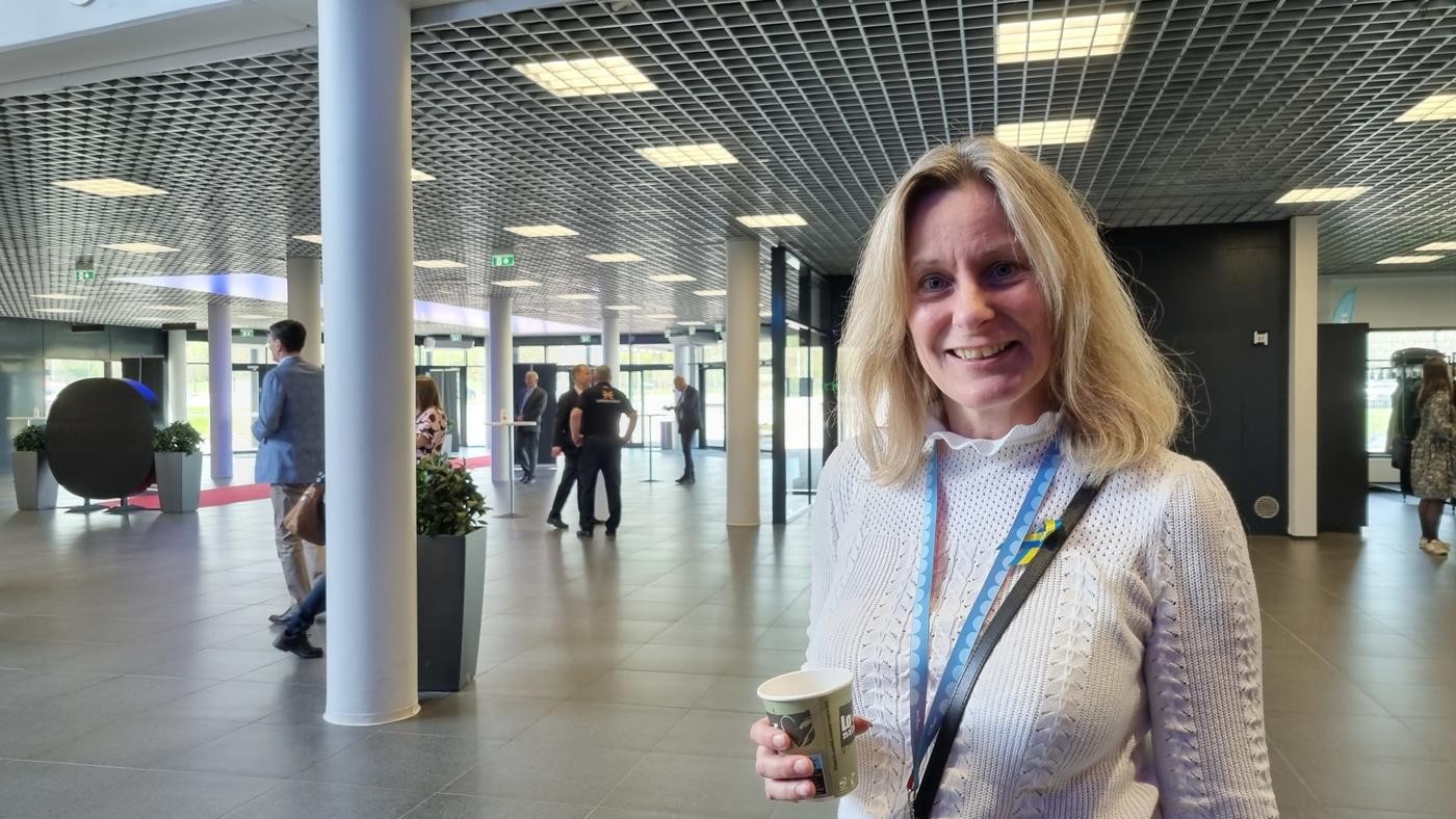 kvinna med ljust hår i stort ljust rum med pelare