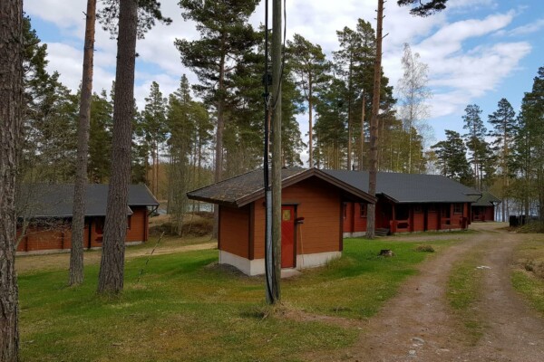 tre stugor i skogsområde vid havet