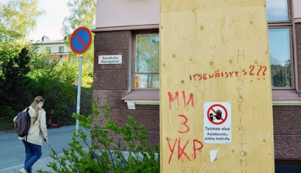 Hög fanerlåd invid husvägg och park