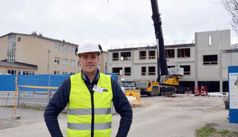 en man i vit hjälm vid en byggarbetsplats