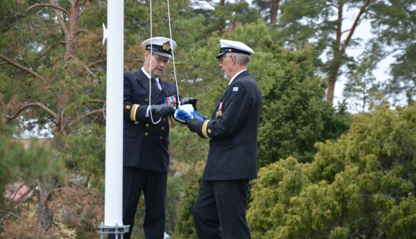 två officerare hissar en flagga