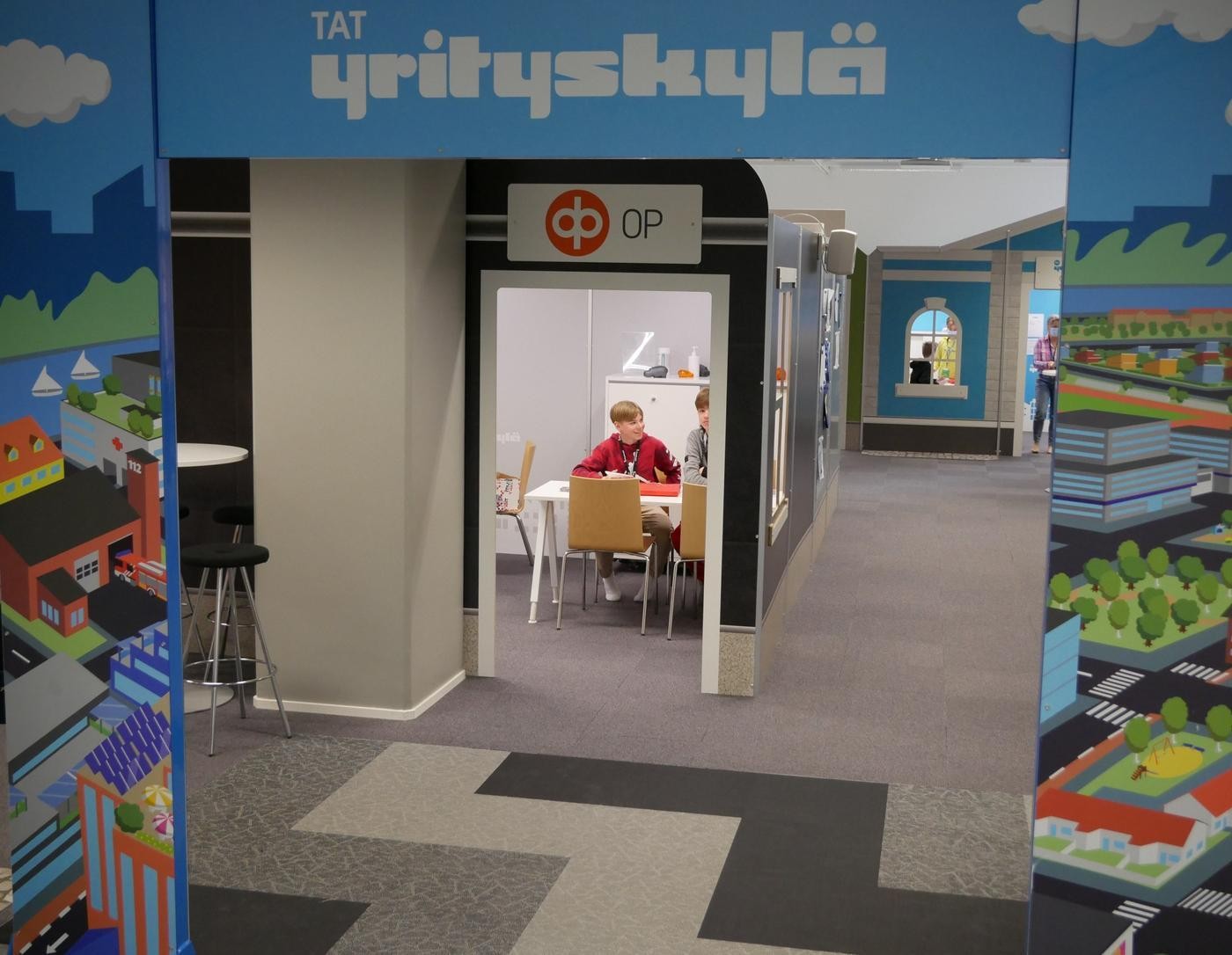 Två pojkar och volontär i Företagsbyn.