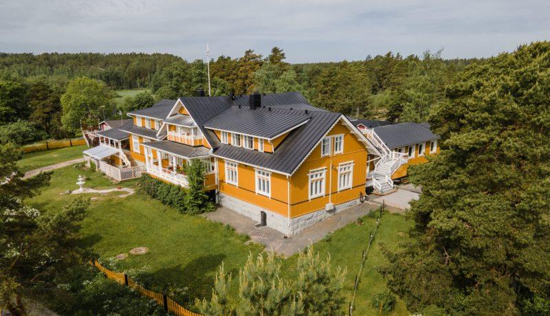 En stor gul trävilla i naturskönt landskap