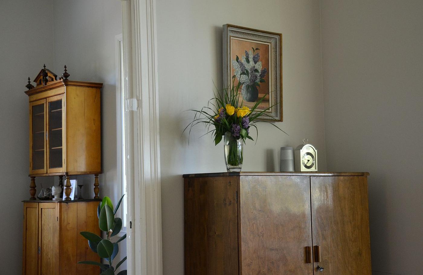 Gamla möbler, tavla och vas med blommor