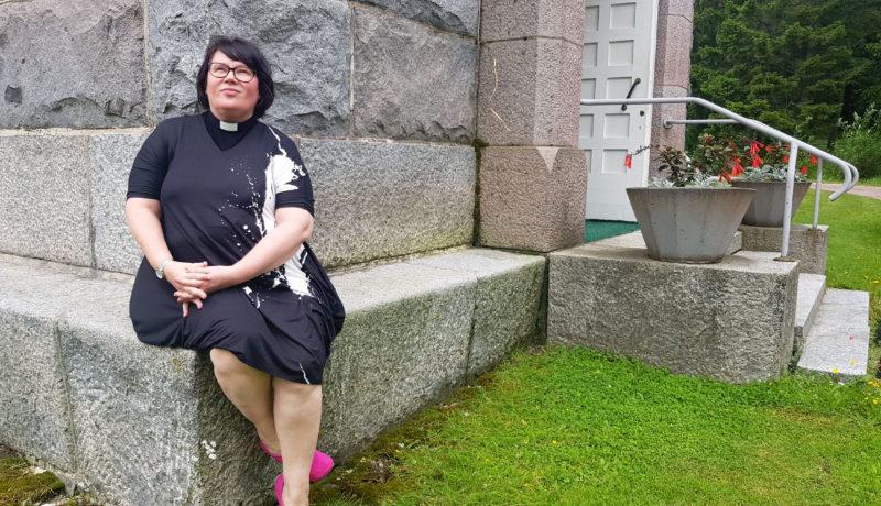 dam sitter vid en kyrkvägg