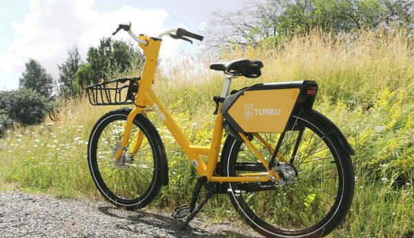 En gul cykel med korg vid sidan av en grusväg.