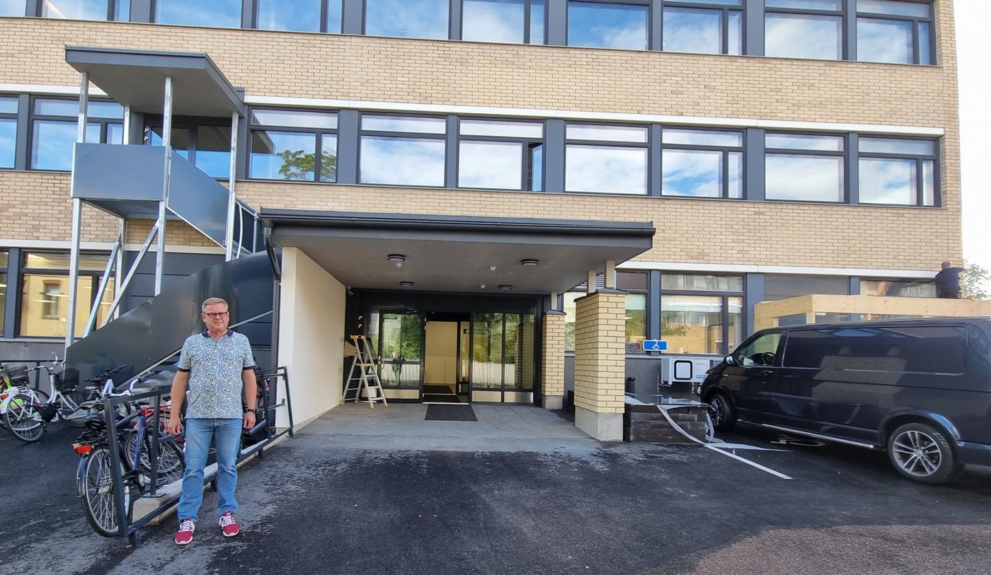 Man framför skolbyggnad