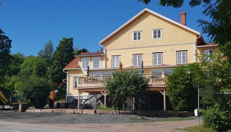Gul träbyggnad med uteservering i två plan