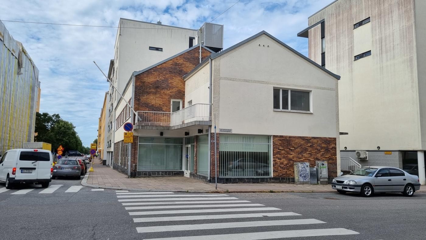 ett litet ljusrappat hus i stadsmiljö