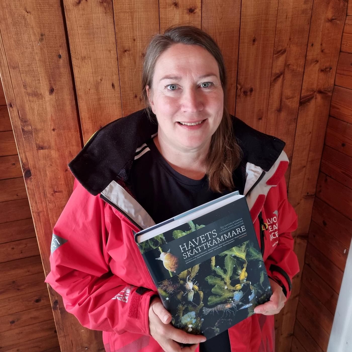 Kvinna håller i boken.