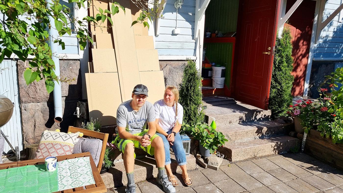 Man och kvinna framför trähus.