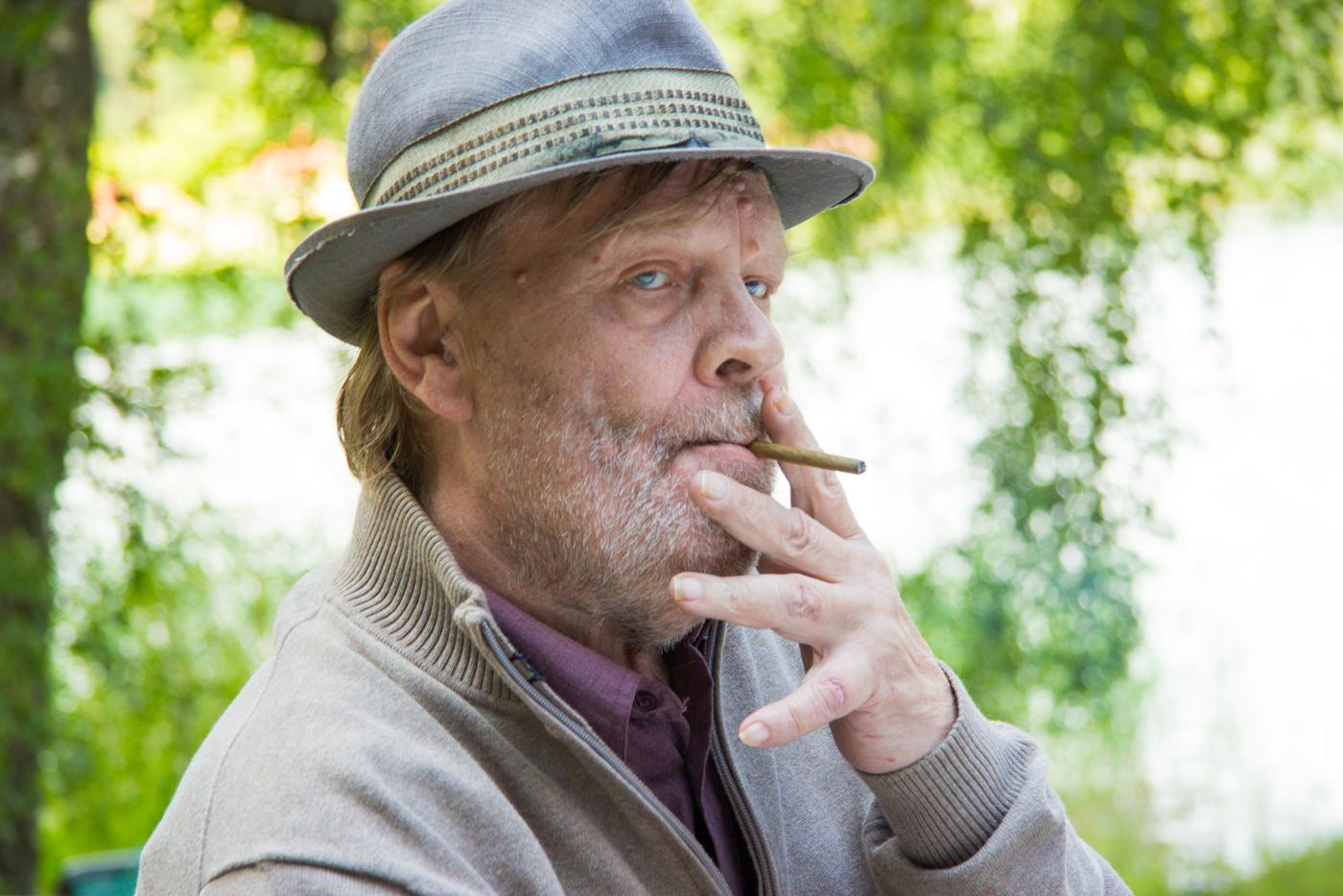 En man med en cigarill i munnen.