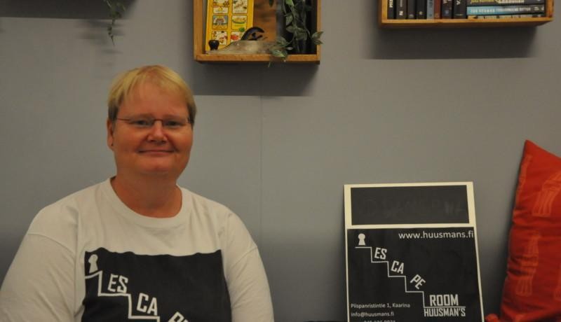Maria Huusman med escape room-skylt