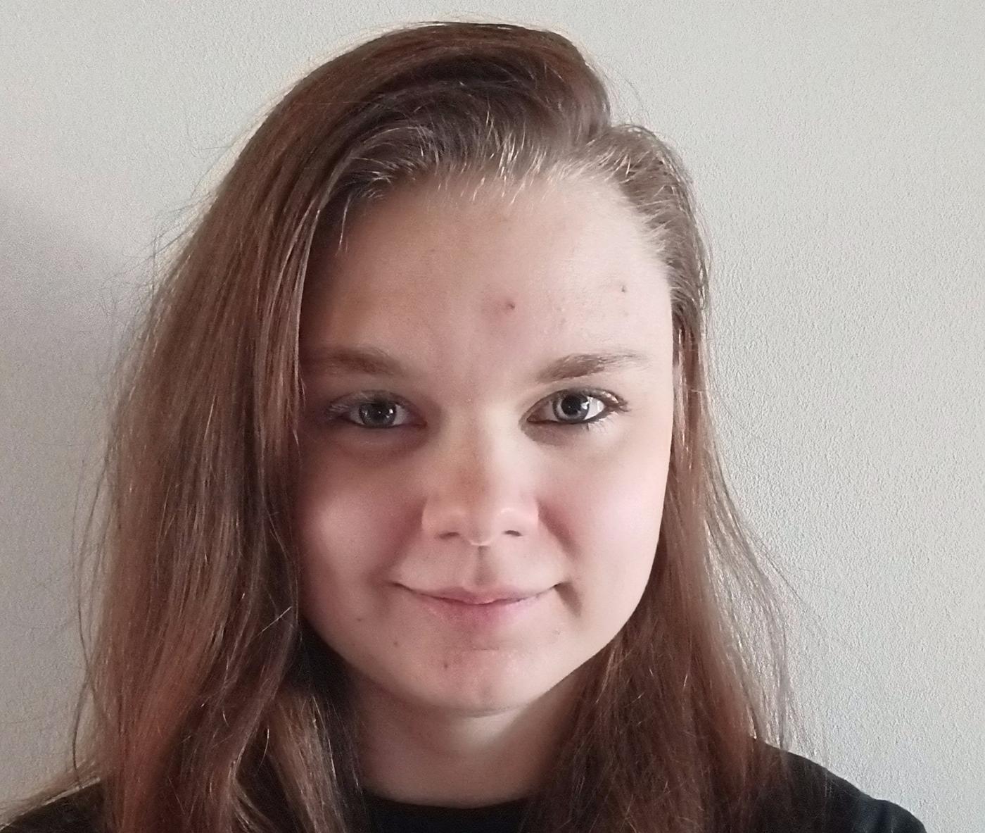 ung kvinna med långt hår tittar rakt in i kameran