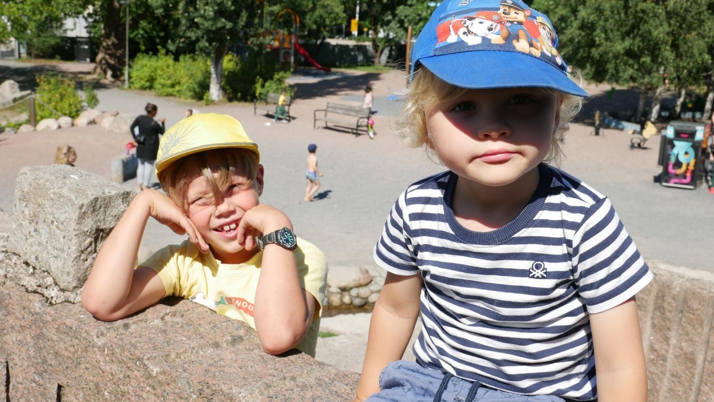 två pojkar vid en stenmur