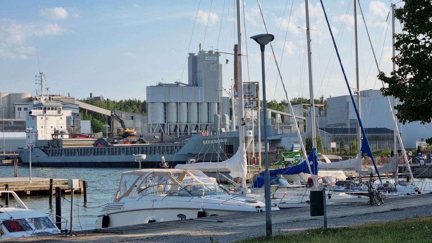 segelbåtar med stort fartyg och fabrik i bakgrunden