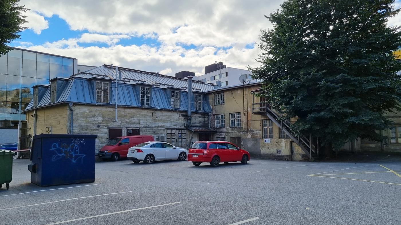 slitna gamla trähus med bilar parkerade framför