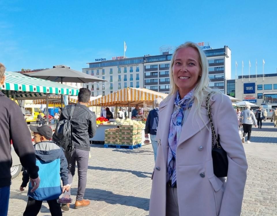 kvinan i rosa kappa på ett torg, blå himmel i bakgrunden