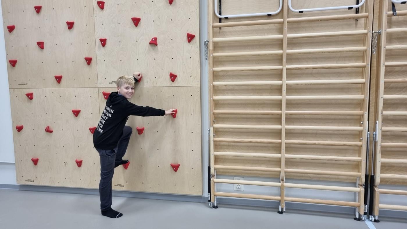 pojke vid klättervägg och ribbstolar