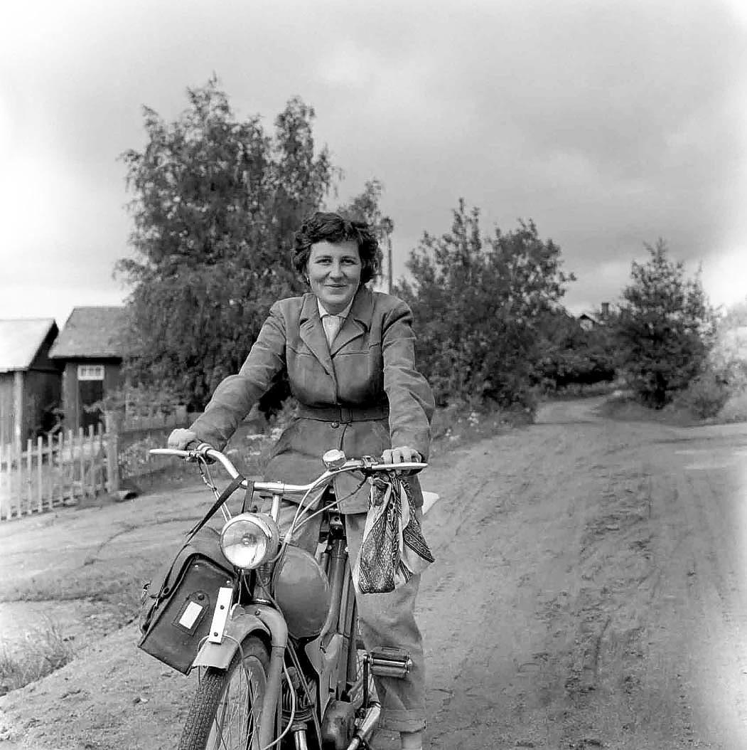 Ett svartvitt foto på en kvinna på moped.