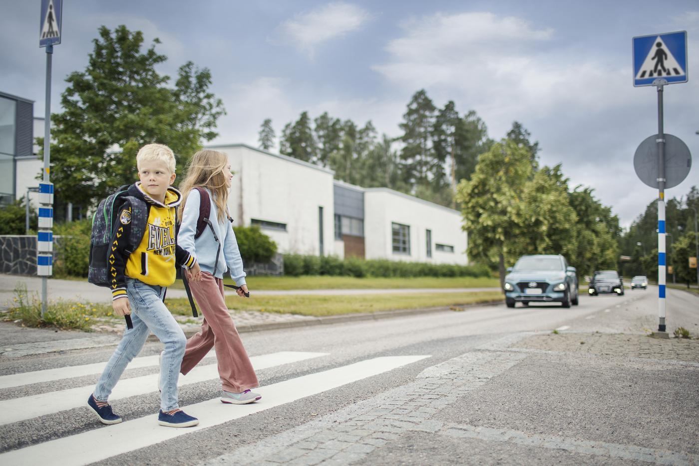 Två barn går över ett övergångsställe