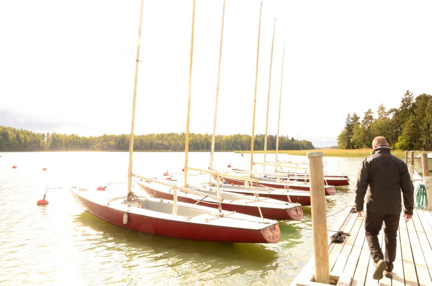 en man går på en brygga med segelbåtar i rad