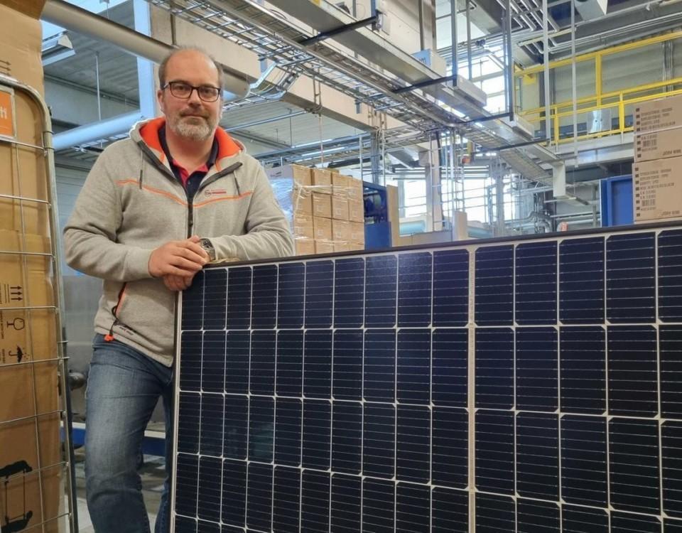 Man står vid en solpanel,