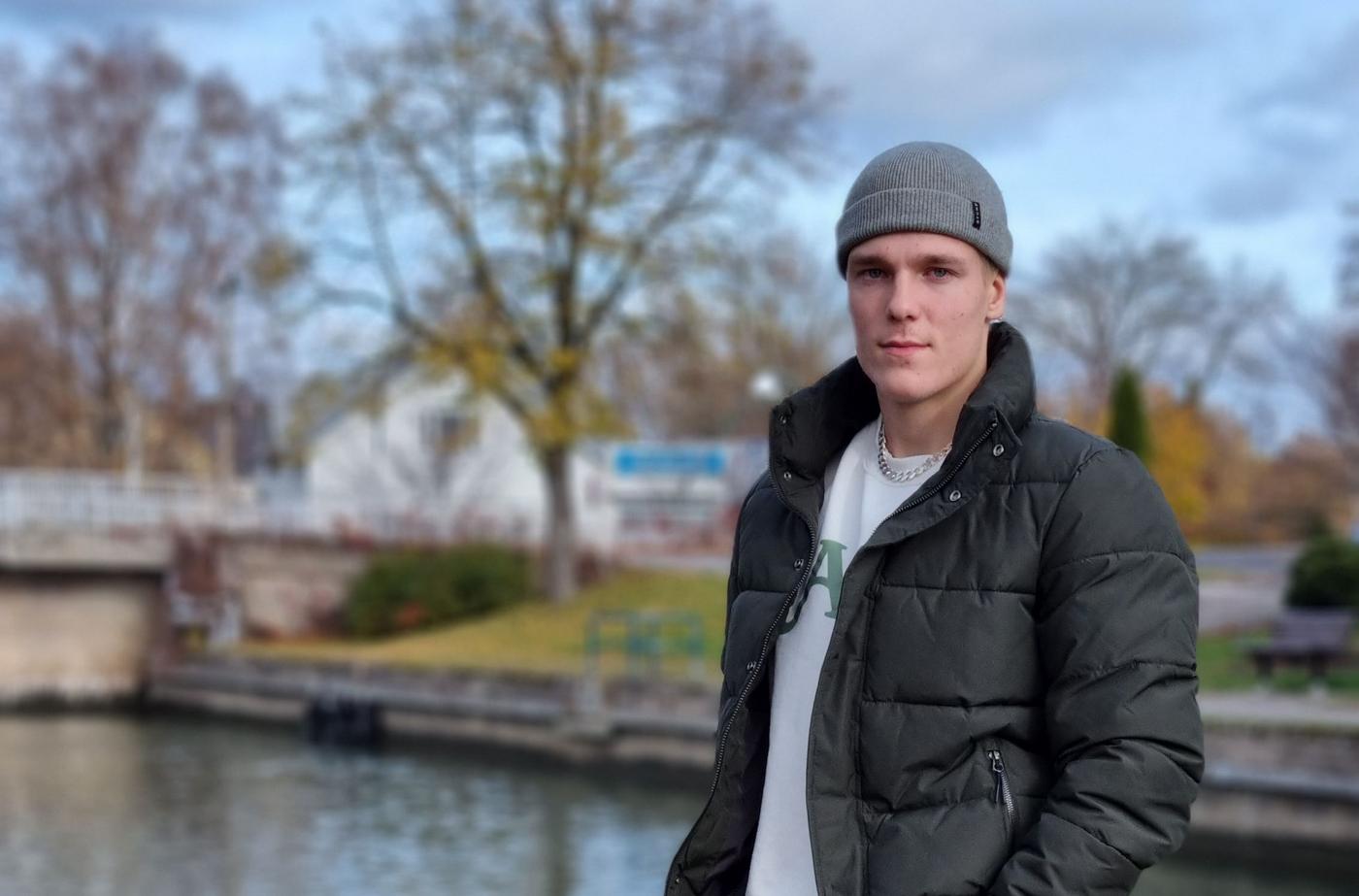 ung man med grå mössa vid vatten