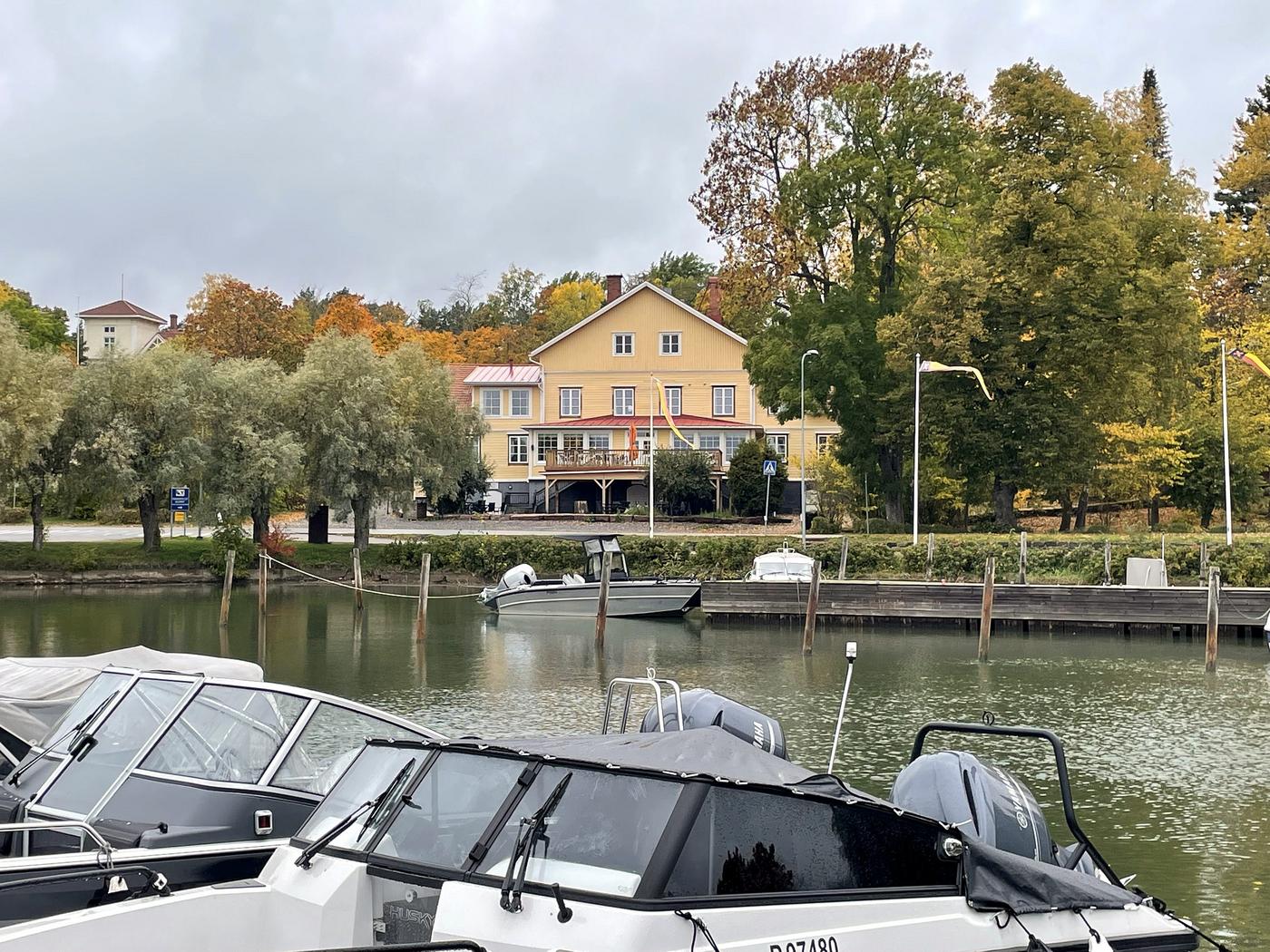 Stort gult hus med stor balkong på andra sidan av en hamnbassäng