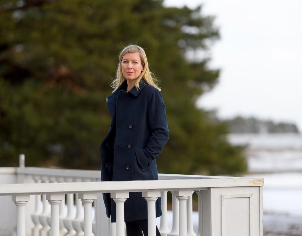 Kvinna som står utomhus vid ett vitt staket