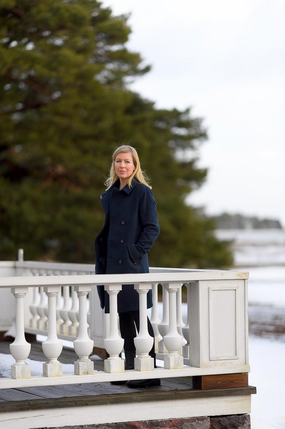 Kvinna som står utomhus vid ett vitt staket