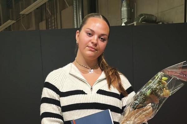 Ung kvinna i randig tröja håller i blombukett