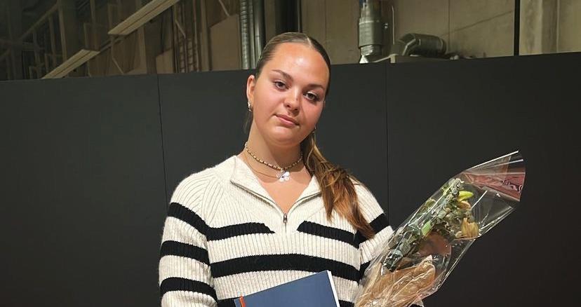 Ung kvinna i randig tröja håller i blombukett