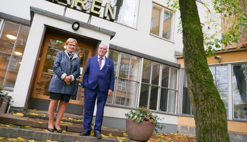 en man o en kvinna framför ett hus