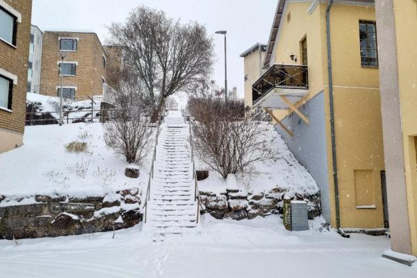 Snötäckta trappor mellan bostadshus