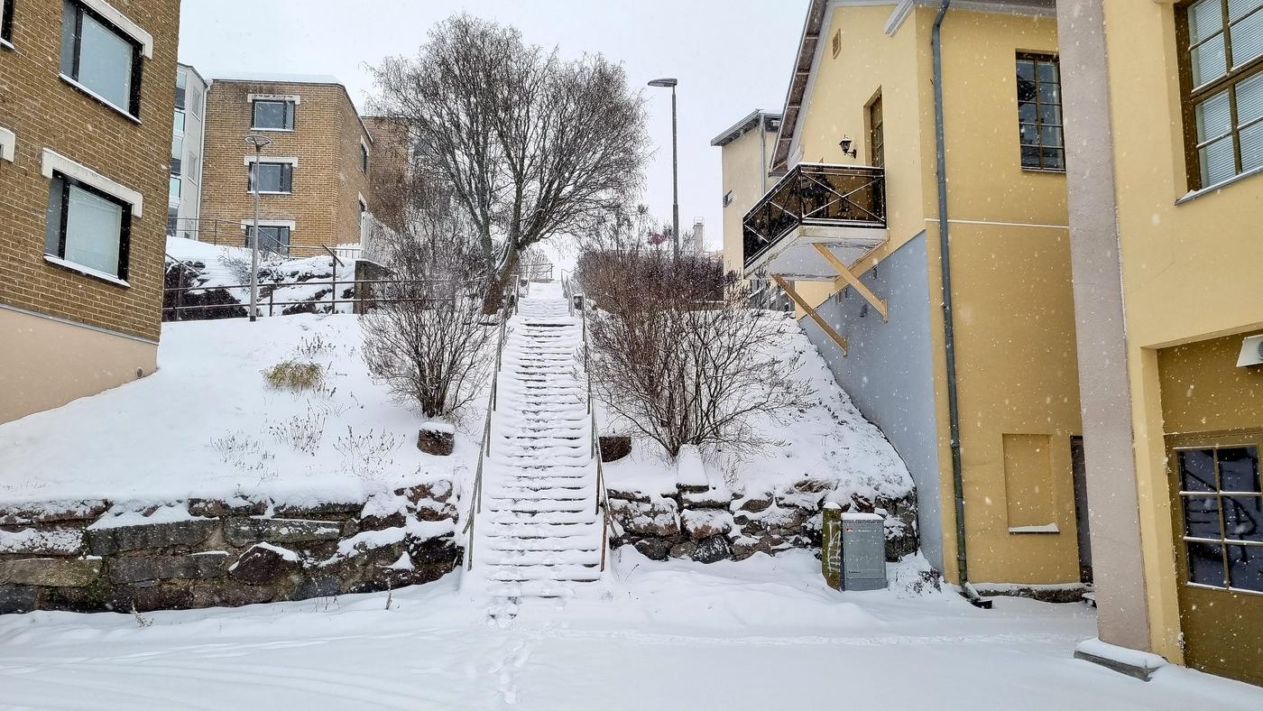 Snötäckta trappor mellan bostadshus