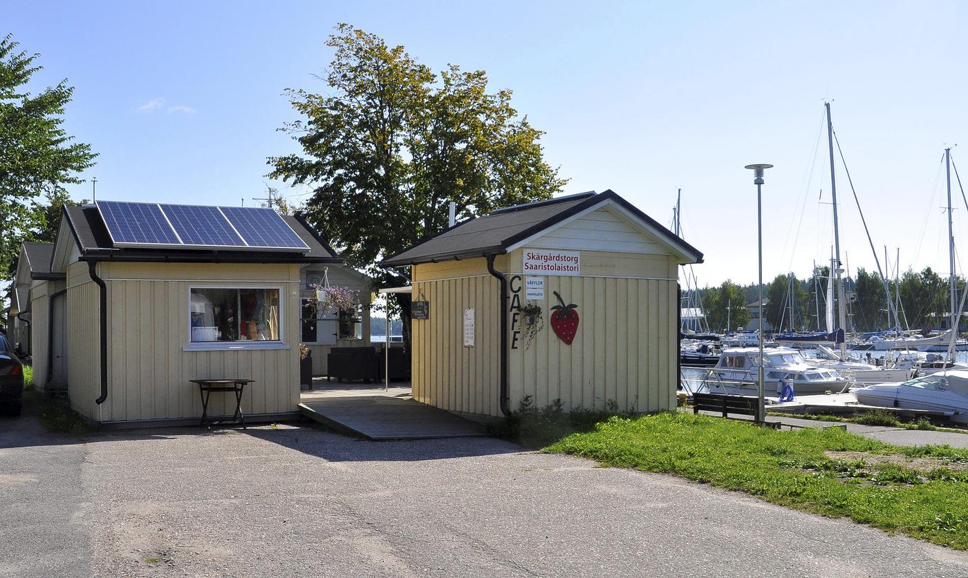 Gula små försäljningsstugor intill en hamn