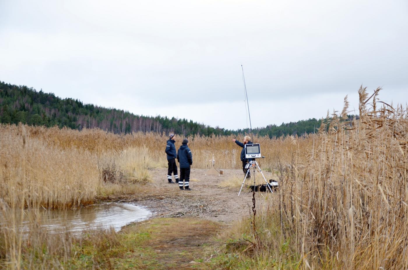 tre män och en antenn på en strand