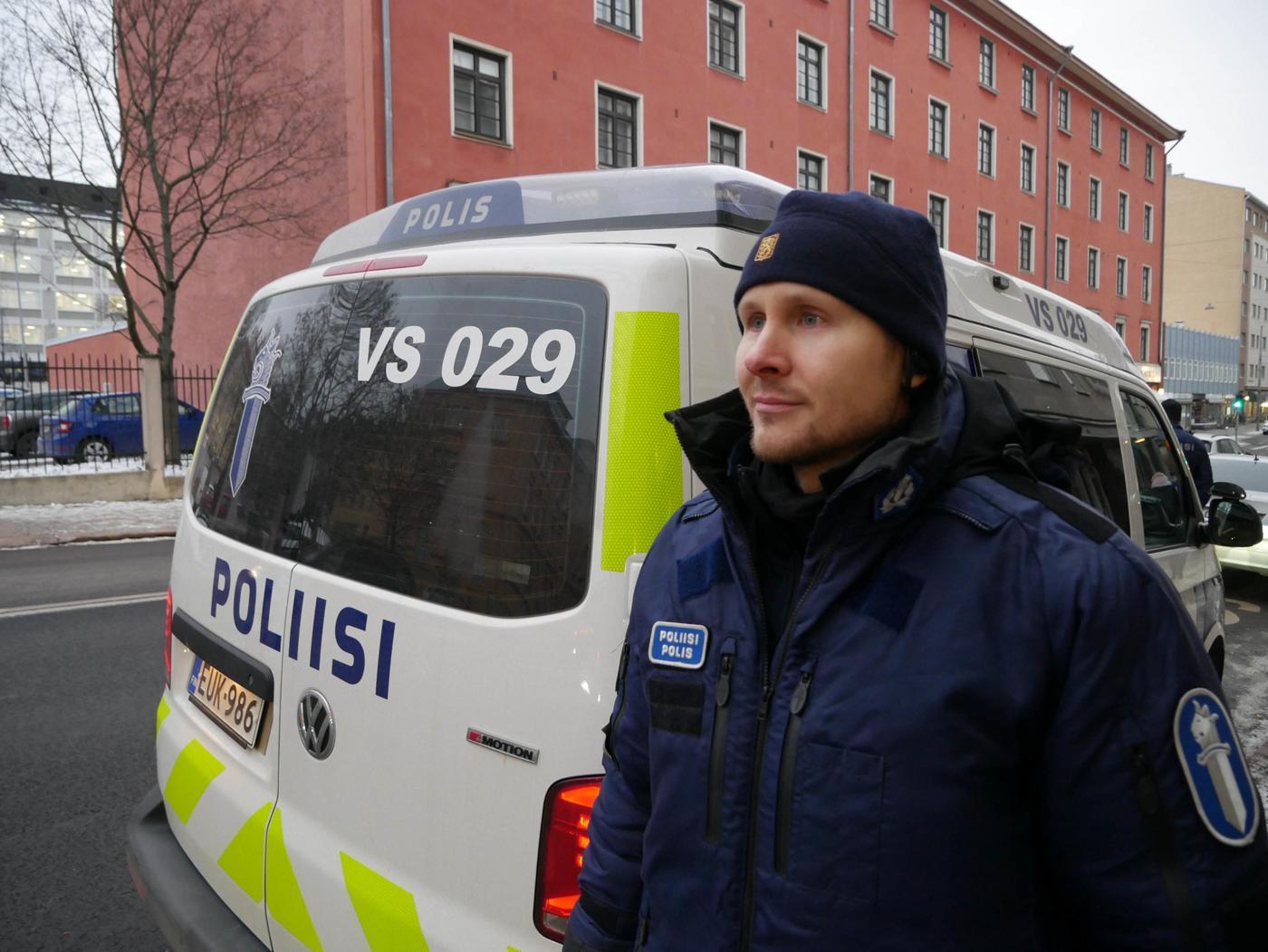 en polis står framför en polisbil